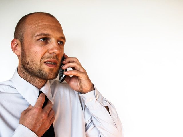 Man in a white dress shirt talking on a phone