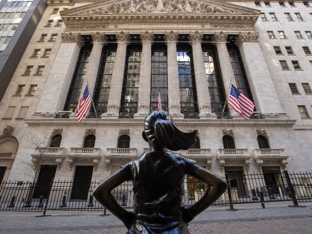  Fearless Girl sculpture in front of New York Stock Exchange building in Wall Street area, shot from behind the statue. 