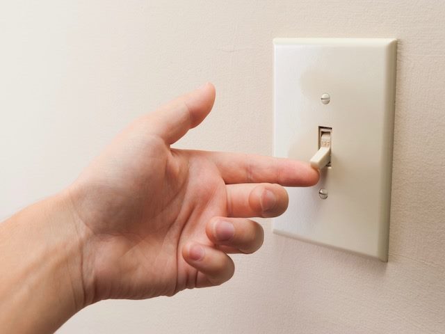 hand turning on a light