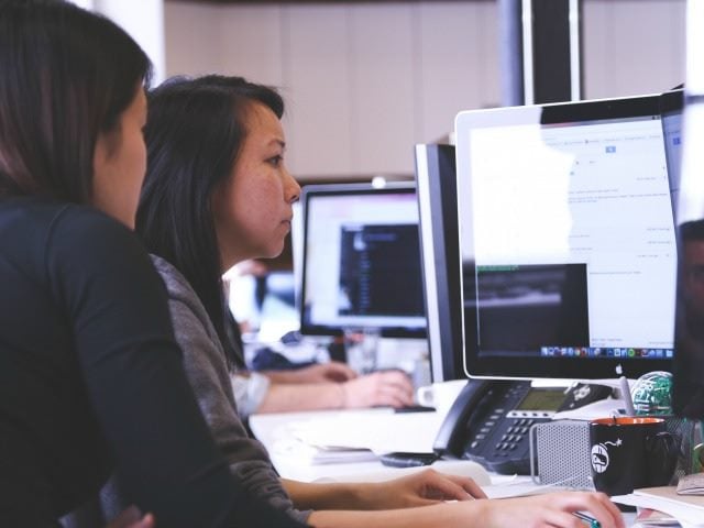two women looking at a computer