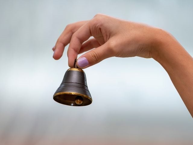 A hand ringing a bell for customer service 