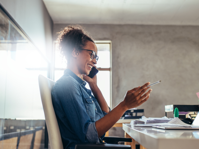 A happy woman on the phone talking to a AI support agent - conversational AI concept