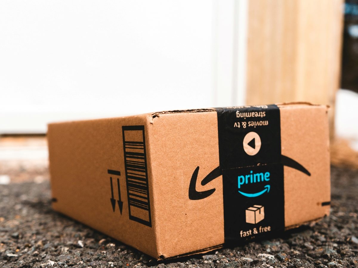 An Amazon Prime-labeled box on the ground in front of a house.