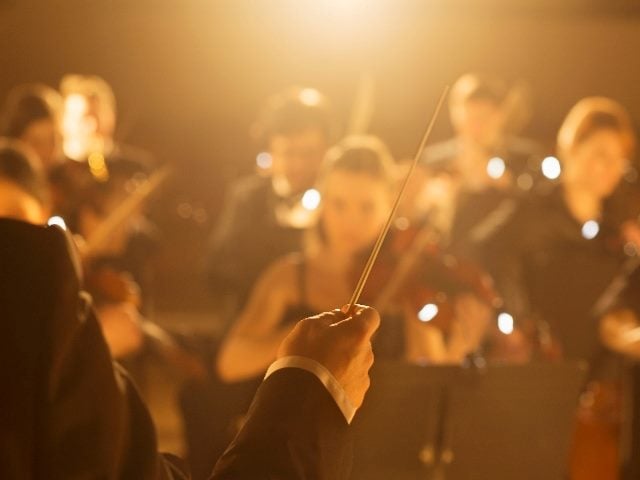 Conductor leading orchestra, just like brands can lead customer journey orchestration.