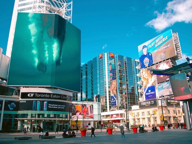 LCD billboard  of a  diver  breaching the  water, street  scene in  Toronto