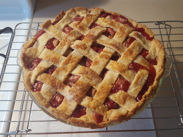 strawberry rhubarb pie cooling on a rack