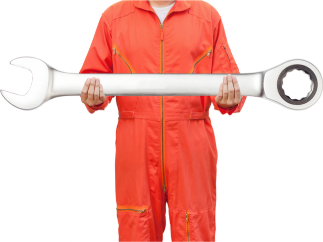 A mechanic in an orange jumpsuit holding a giant wrench.