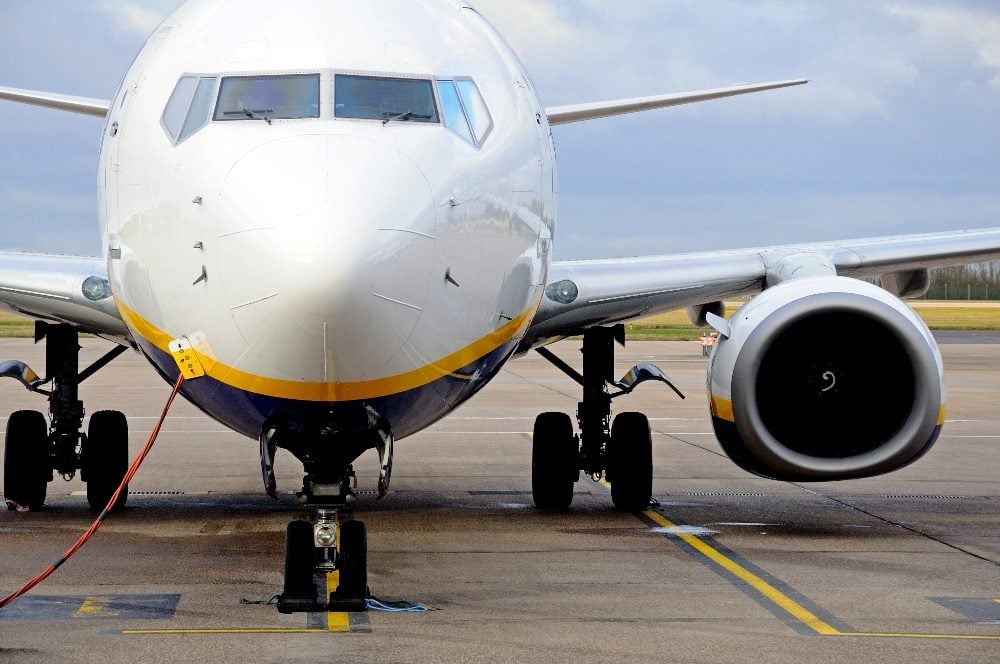 Front view of Boeing 737-800 Aircraft parked in an airport with one wing and one engine emphasized in piece about organizational silos and how the airline industry avoids them.