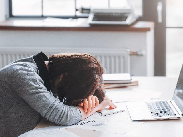 Tired female employee having nap at desk.  
