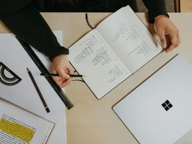 Overview shot of someone writing in a notebook.