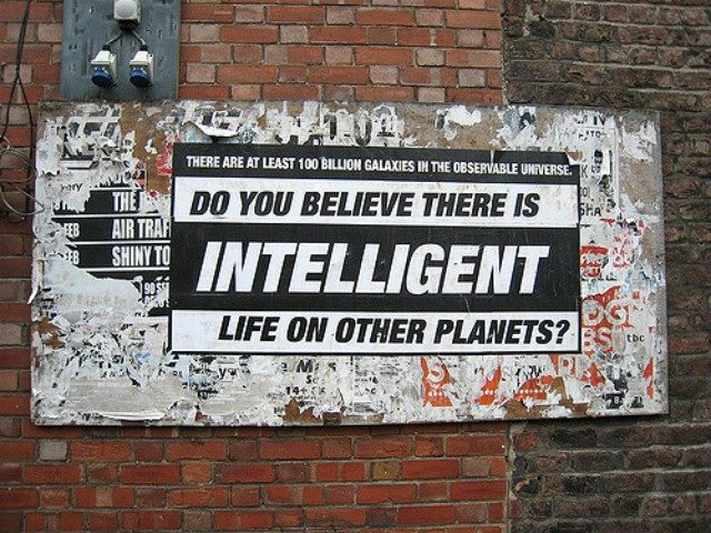 Sign on a brick wall that reads, "Do you believe there is intelligent life on other planets?"