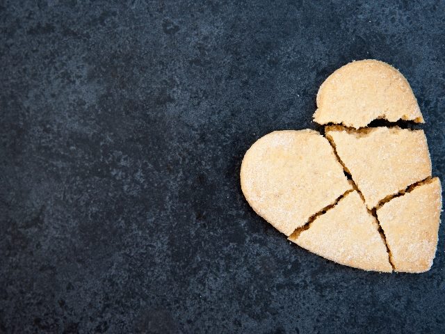 A broken heart-shaped cookie against a dark background in piece about third-party cookie deprecation. 