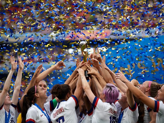 US women's soccer players celebrating together after winning a medal.