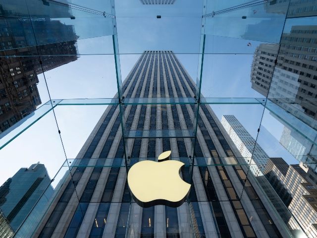 Apple logo is seen at the Apple flagship store on the 5th Avenue in NYC with the camera angle highlighting the building jutting up into the sky.