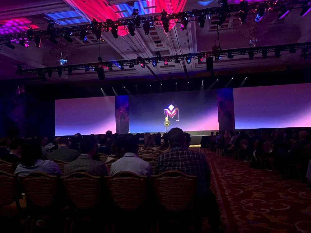 A speaker presents in the event hall at Medallia's Experience '24 conference in Las Vegas.