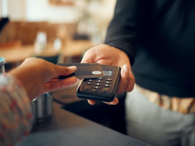Credit card payment, showing employee and customer hands. 