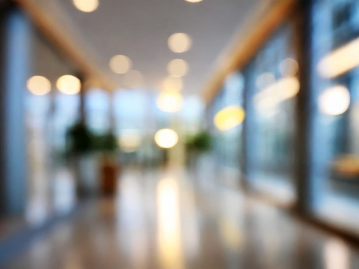 Blurred interior hallway with natural light and reflections on a polished floor, symbolizing lack of clarity and focus.