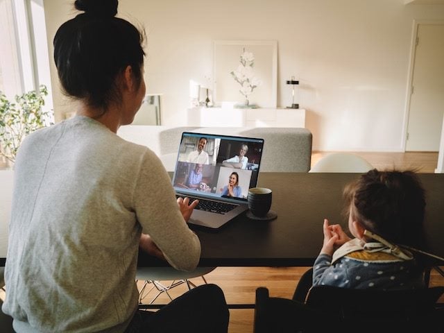 woman on a zoom call with baby offscreen waiting to be fed