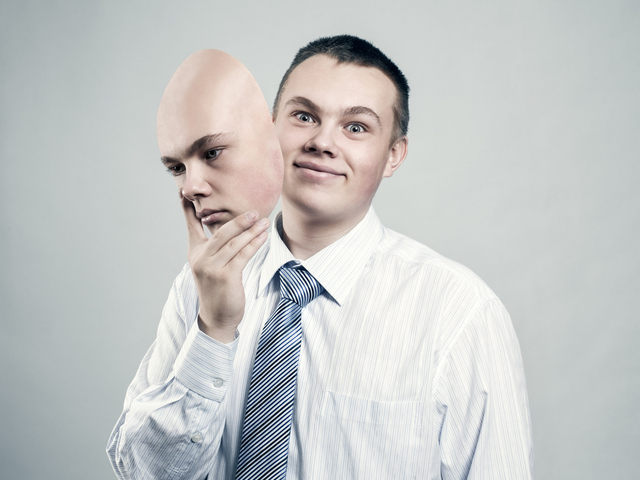 A businessman removes the mask from the face of a bad mood