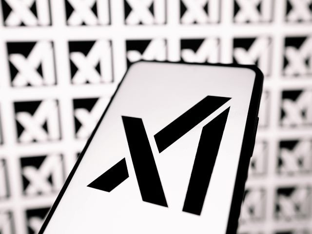 The logo of the newly launched Elon Musk company xAI on a smart phone, with a black on white design on the  phone and white on black in the background.