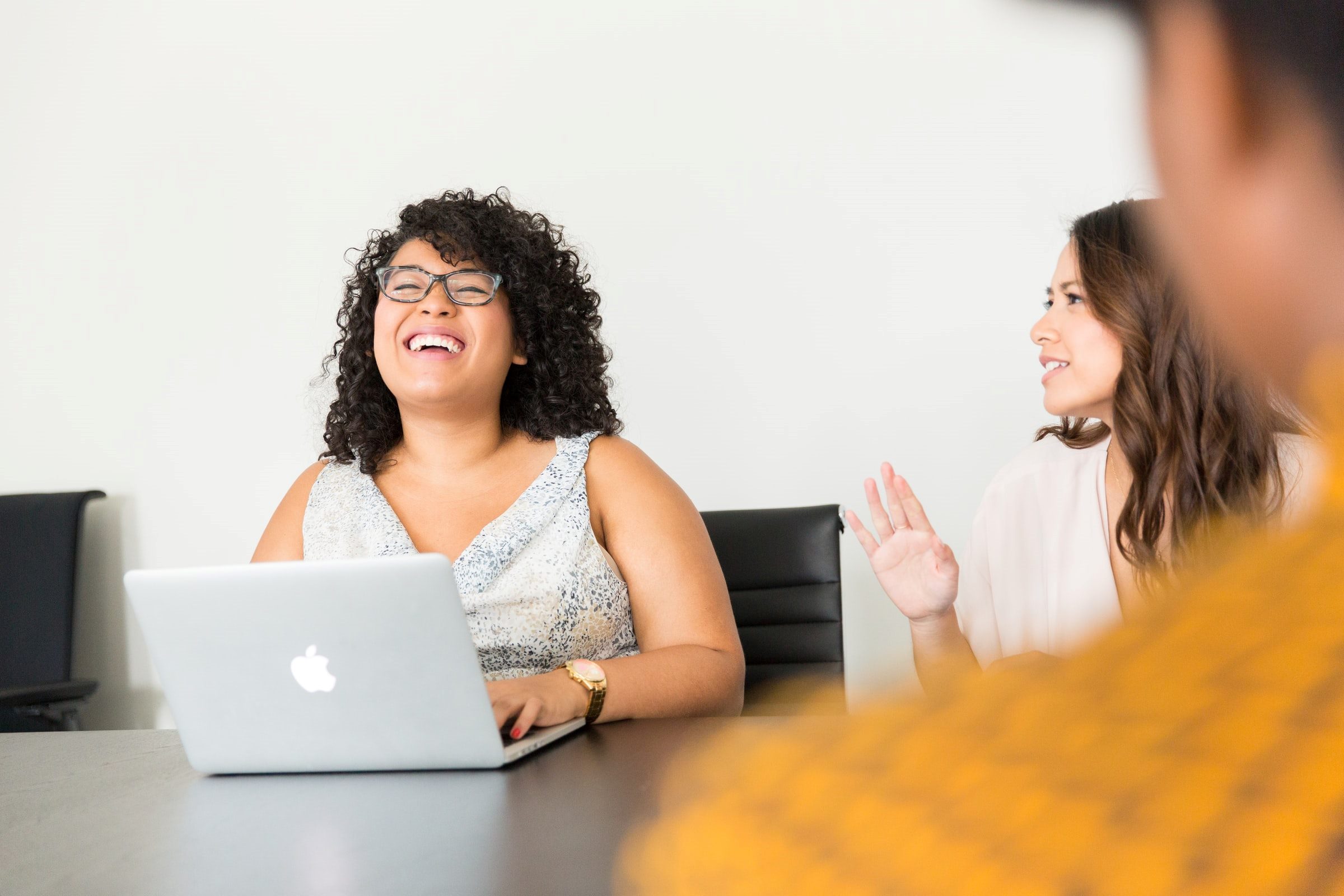 women in conference room with laptop