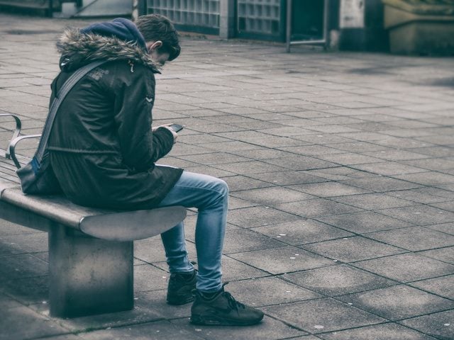 man looking at a cellphone outdoors