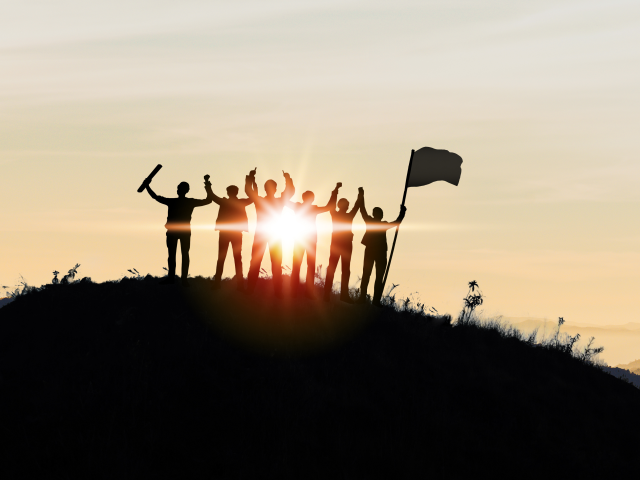 Silhouette of Business team show arm up and flag on top of the mountain.