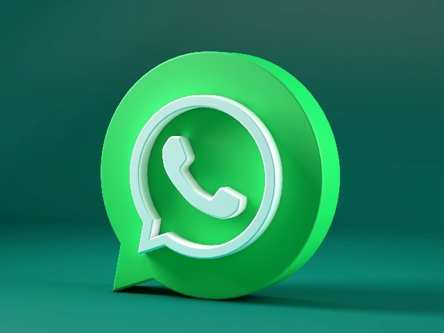 WhatsApp's bright green and white phon e shaped  icon inside a speech bubble isolated on a darker green background in piece about the rising popularity of WhatsApp in the U.S.