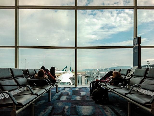 looking at a phone while waiting for a flight in an airport