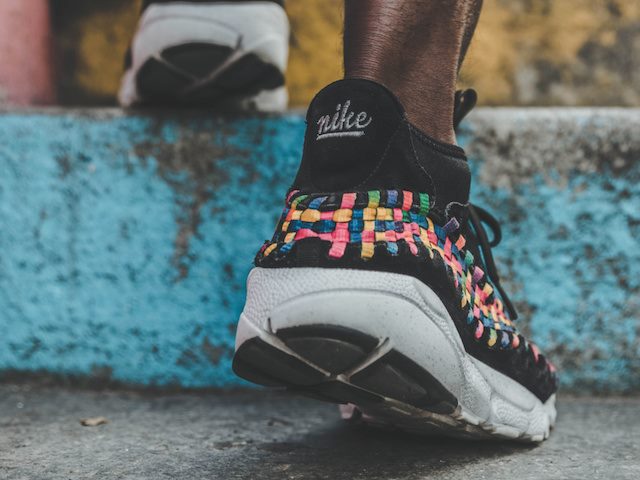 person walking up stairs wearing nike sneakers