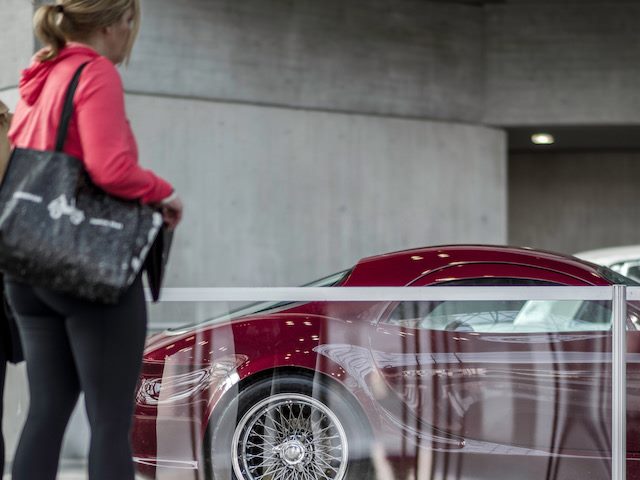 woman looking at a new car through a plastic divider