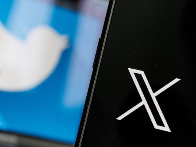 Twitter's previous Blue Bird logo is on the left and blurred with the new "X" logo on the right and in focus, in a piece about X shrinking under Elon Musk. 