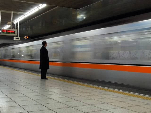 man waiting for a train as one passes him by