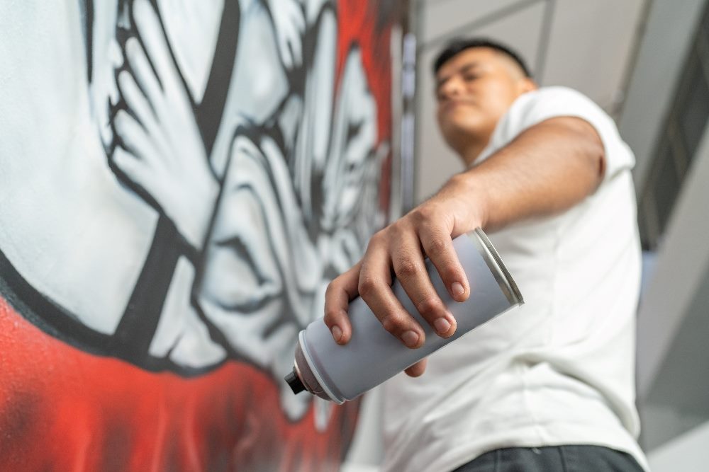 Muralist working in a new urban mural using spray paint in piece about the future of mobile UX design.