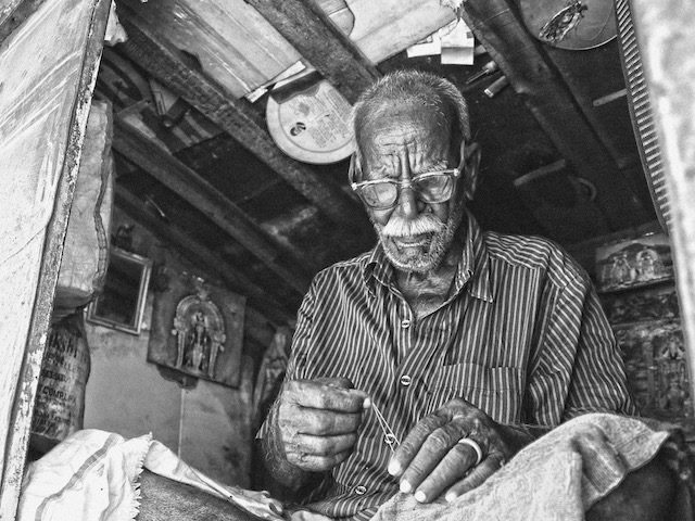 man mending clothing