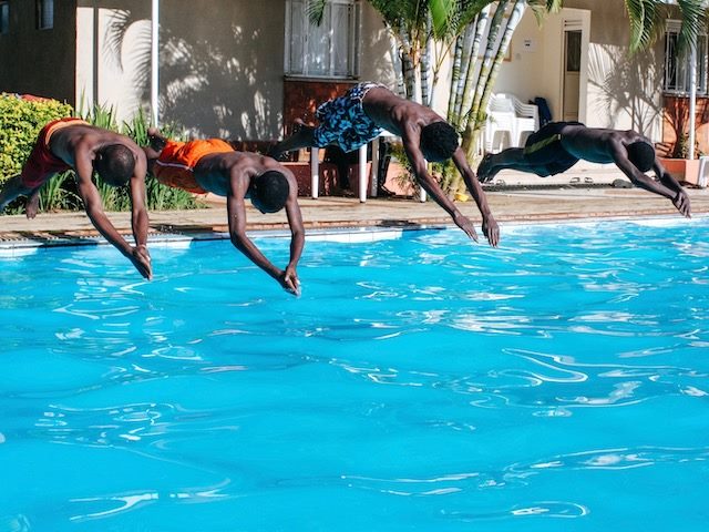 four friend diving into a pool at the same time
