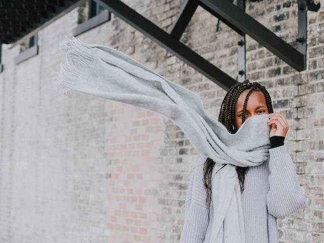 woman hiding behind a scarf