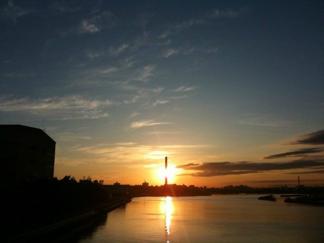 A rising sun over a body of water.