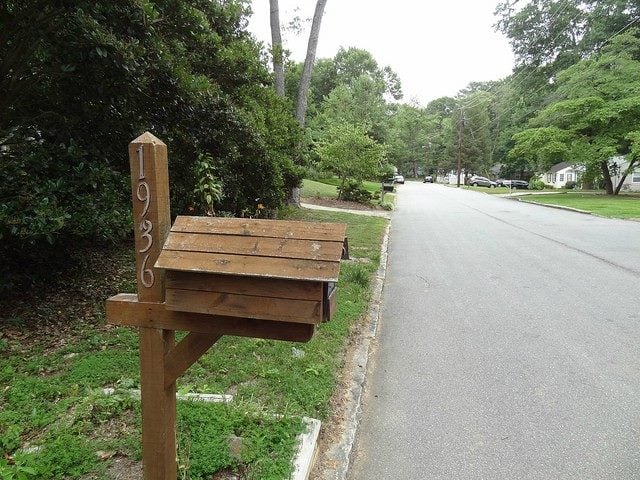 Wooden mailbox close to a street.