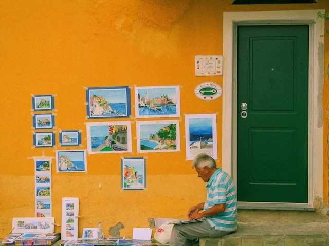 man painting  scenes of his area