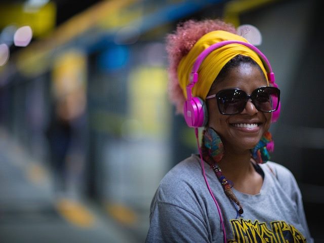 smiling woman listening to her headphones