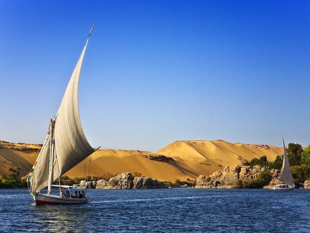 sail boat on smooth water under blue skies