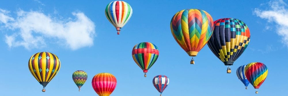 A vibrant scene of multicolored hot air balloons soaring in a clear blue sky, symbolizing the concept of customer delight as they lift off and create an atmosphere of joy and excitement.