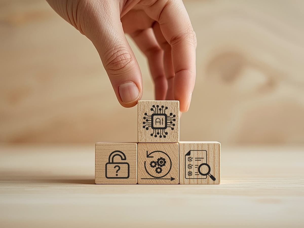 Hand placing an AI-labeled wooden block atop connected blocks showing security, workflow automation and oversight icons, illustrating enterprise AI governance, accountability and interconnected intelligence systems.