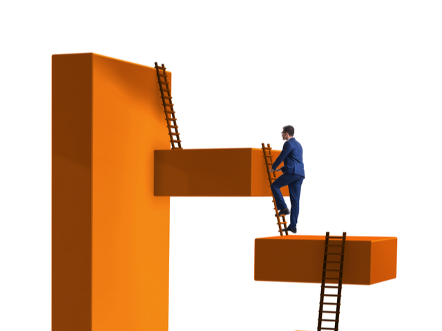 Businessman climbing from block to block overcoming obstacles - blockchain concept
