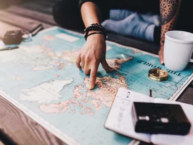 A person planning a trip with a map on a table
