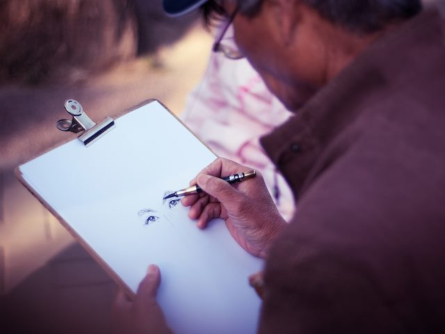 man sketching on a notepad