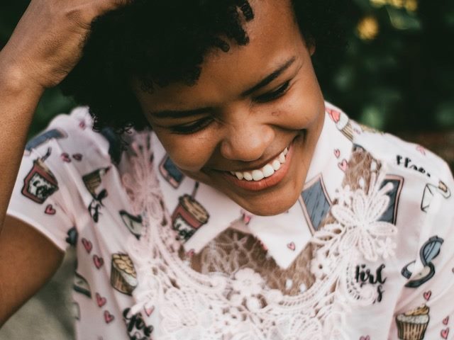 laughing woman touching her head