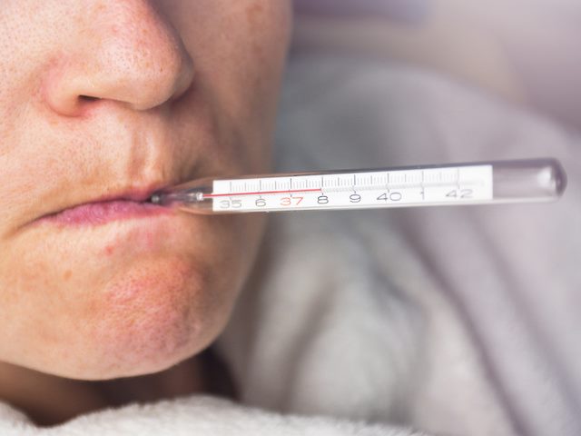 person with thermometer in mouth