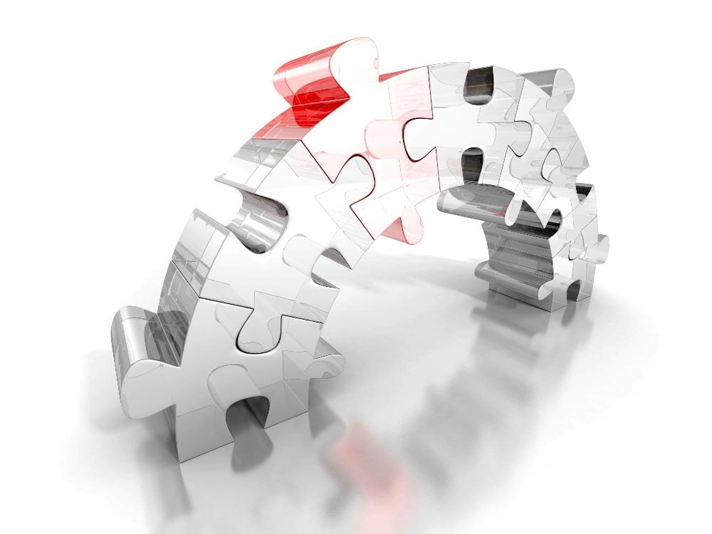 This image features a 3D illustration of a bridge constructed from jigsaw puzzle pieces. The bridge arches from one end to the other, symbolically connecting two points. The puzzle pieces are mostly in grayscale, with a few in red, adding a visual highlight in piece about building customer-centricity.